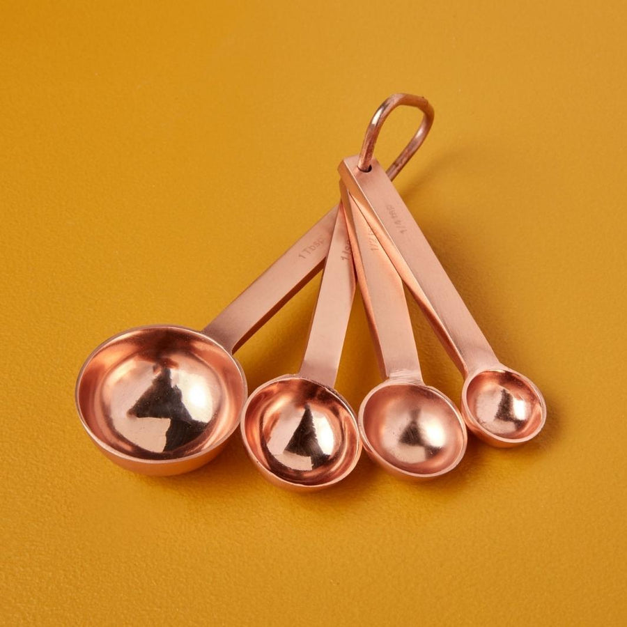 Set of 4 Acadia Copper Measuring Spoons on a Mustard Background | Be Home US | Measuring & Mixing @ Spice Craze®