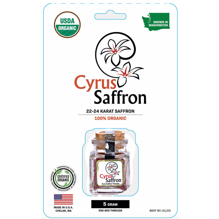 Cyrus Saffron 5 grams of organic saffron in a clear glass jar with a cork stopper and yellow ribbon, presented on its retail blister card packaging with USDA Organic and Washington state grown badges.