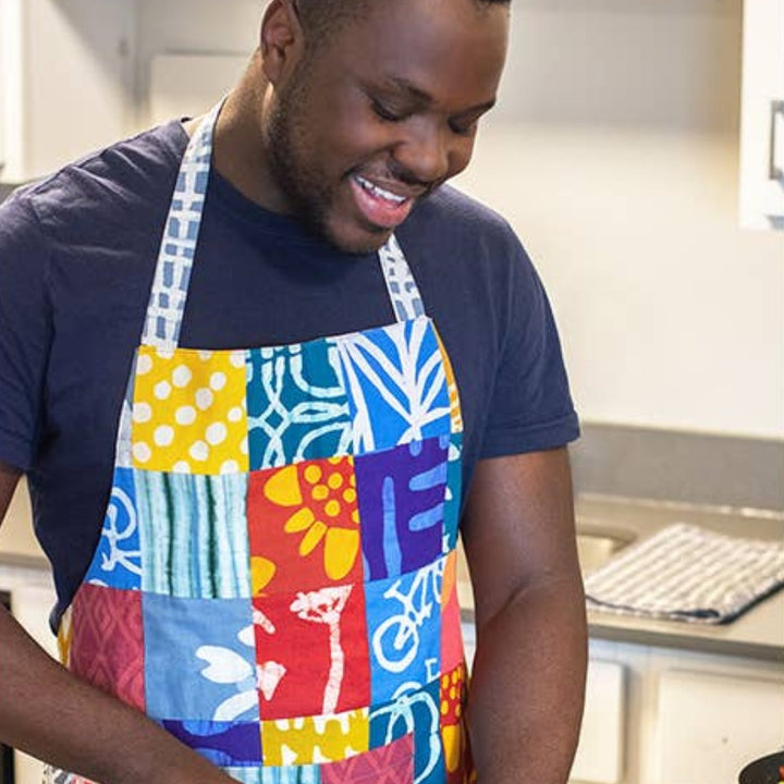 Man Cooking in Kitchen Wearing Reversible Patchwork Apron | Global Mamas® | Aprons & Linens @ Spice Craze®